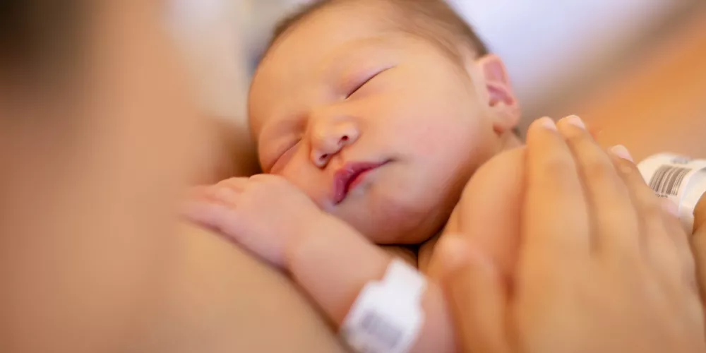 Newborn baby held skin-to-skin moments after birth