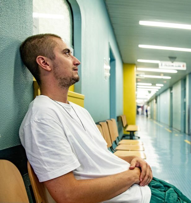 First-time father sitting alone in a hospital hallway before the delivery